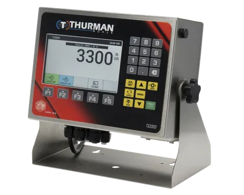 TS3302 analog scale indicator in a NEMA 4X stainless steel washdown housing on a desk and wall stand, 7-inch color display and numeric keypad.