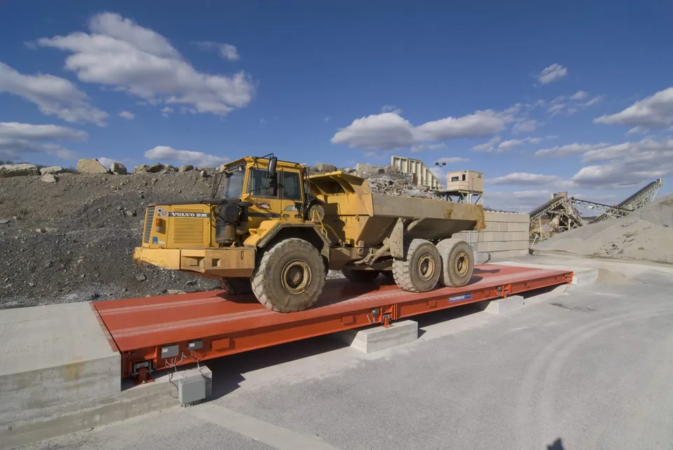 Articulated off-road haul truck on a Thurman Diamondback 8560XD steel deck truck scale at a quarry